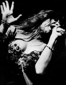 Photo of Janis Joplin singing around the late 1960s.
