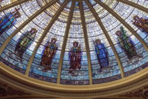 Photo of interior view of dome in the First Presbyterian Church in Orange Texas featuring various stained glass art of saints and angels.