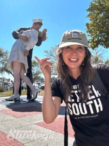Stephanie Stuckey standing in front of the Smooching Sailor statue in Sarasota.